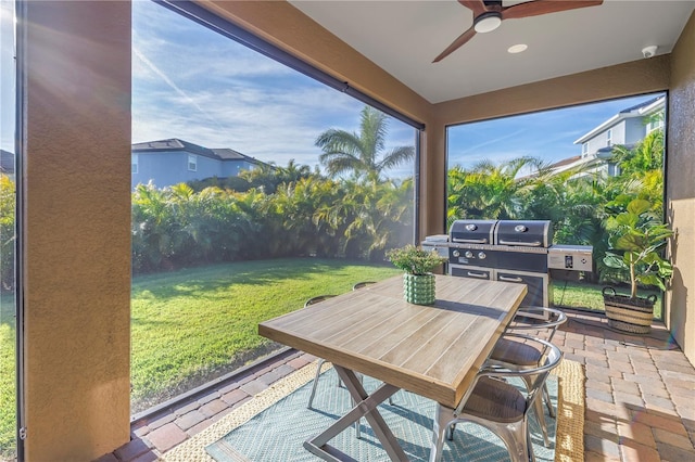 sunroom / solarium featuring ceiling fan