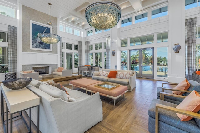 living room with plenty of natural light, a towering ceiling, and a chandelier