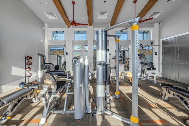 exercise room with carpet flooring and a towering ceiling