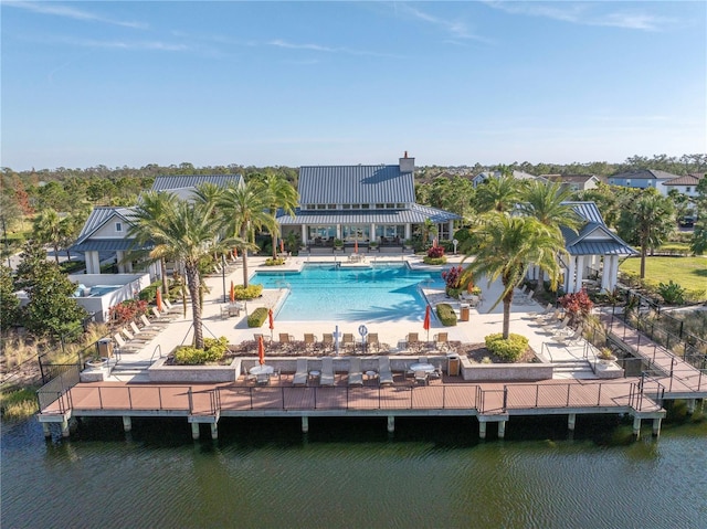 back of house featuring a patio area, a water view, and a community pool