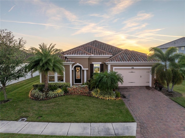 mediterranean / spanish-style home featuring a lawn and a garage