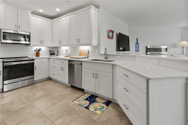 kitchen featuring sink, light tile patterned floors, light stone counters, white cabinetry, and stainless steel appliances