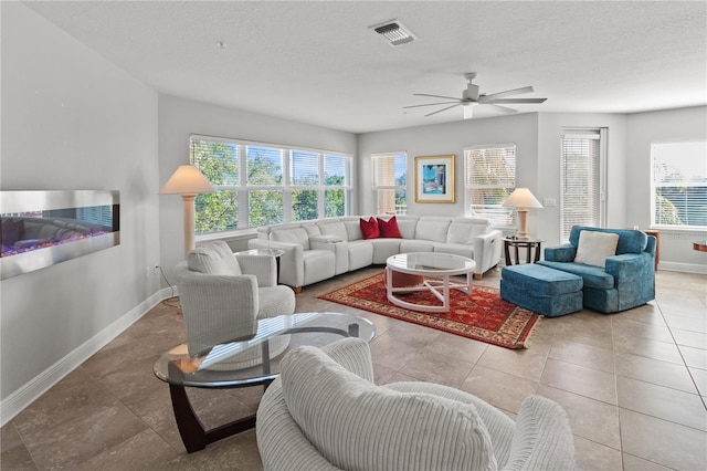 tiled living room featuring ceiling fan and a textured ceiling