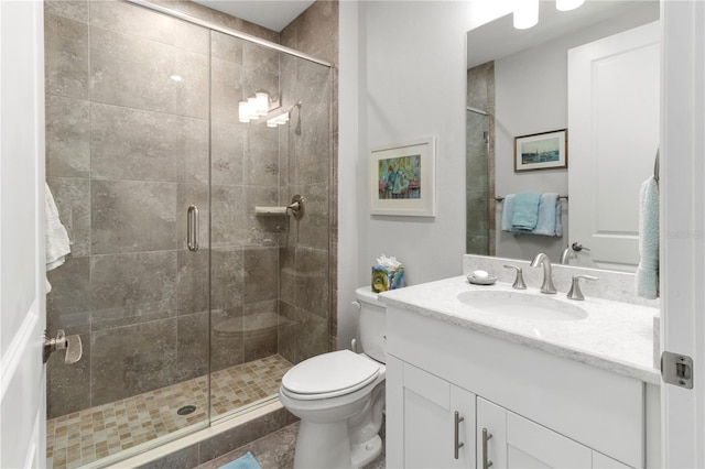 bathroom with tile patterned floors, toilet, vanity, and walk in shower