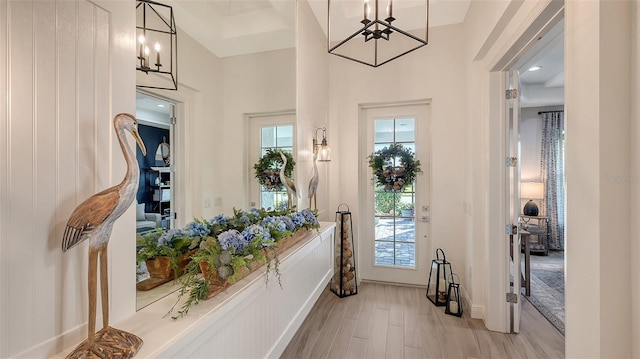 entrance foyer featuring a wealth of natural light, an inviting chandelier, a high ceiling, and light wood-type flooring