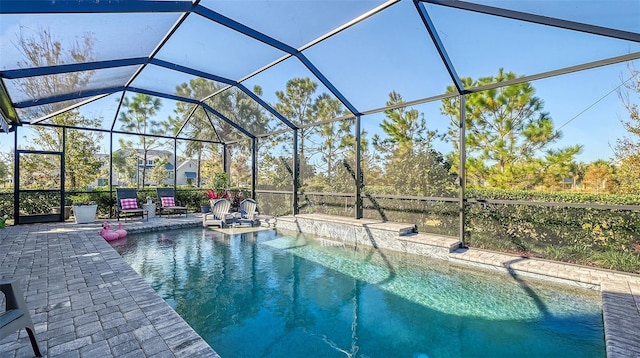 view of swimming pool featuring a patio area and a lanai