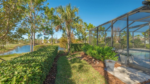 view of yard with glass enclosure and a water view