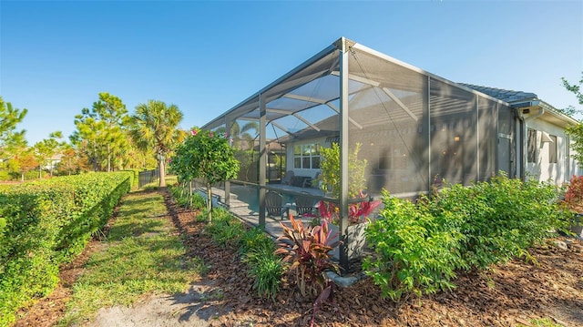 view of side of home featuring glass enclosure