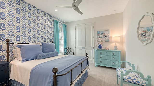 bedroom featuring ceiling fan, a closet, and light colored carpet