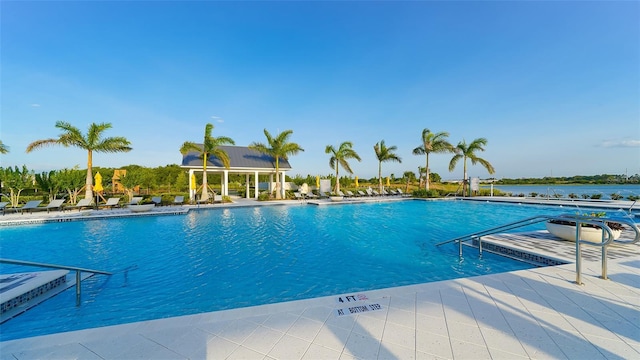 view of pool featuring a patio area and a water view