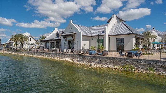 back of property featuring a water view