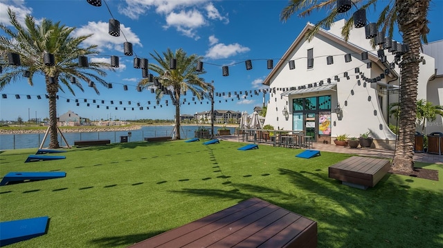 view of community featuring a water view and a yard