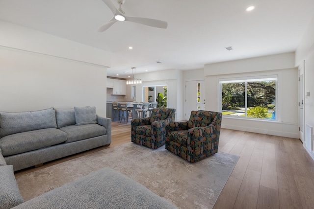 living room featuring ceiling fan and light hardwood / wood-style floors