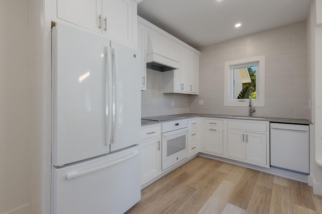 kitchen featuring sink, white cabinets, white appliances, and light wood-type flooring