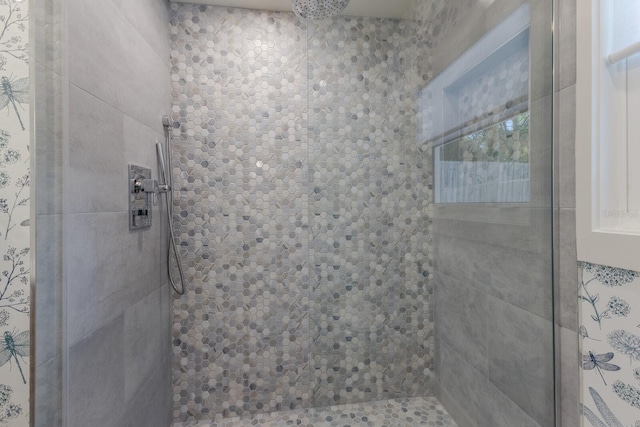 bathroom with a healthy amount of sunlight and a tile shower