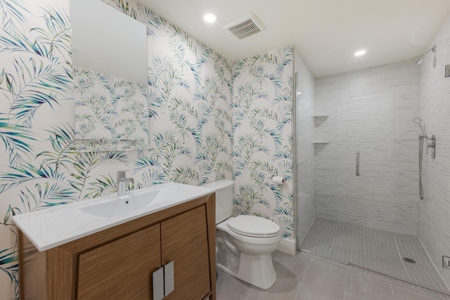 bathroom with tile patterned flooring, vanity, toilet, and a shower with door