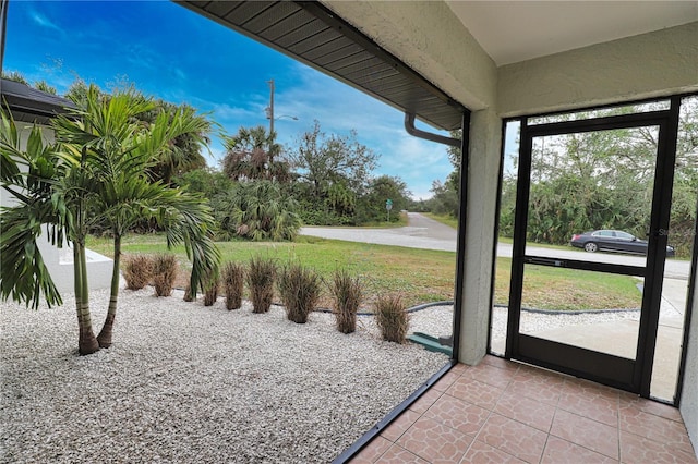 doorway to outside with light tile patterned floors