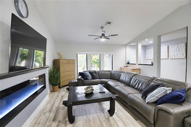 living room featuring light hardwood / wood-style floors, vaulted ceiling, and ceiling fan