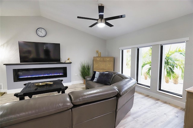 living room featuring ceiling fan, vaulted ceiling, and light wood-type flooring