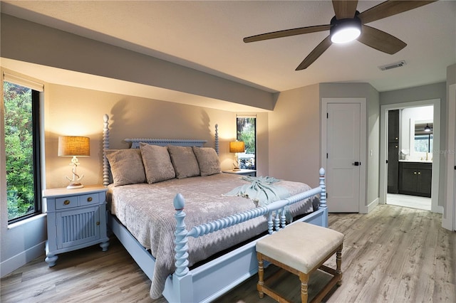 bedroom with ceiling fan, light wood-type flooring, and ensuite bathroom