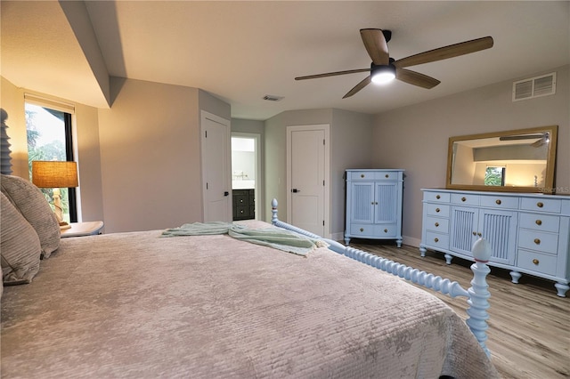 bedroom with ensuite bath, ceiling fan, and light hardwood / wood-style flooring