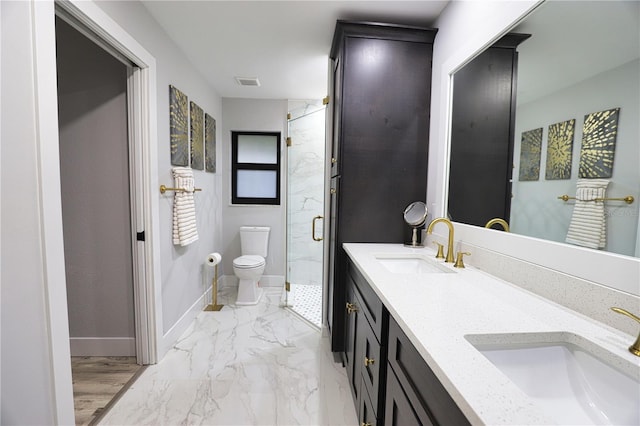 bathroom with vanity, toilet, and a shower with door