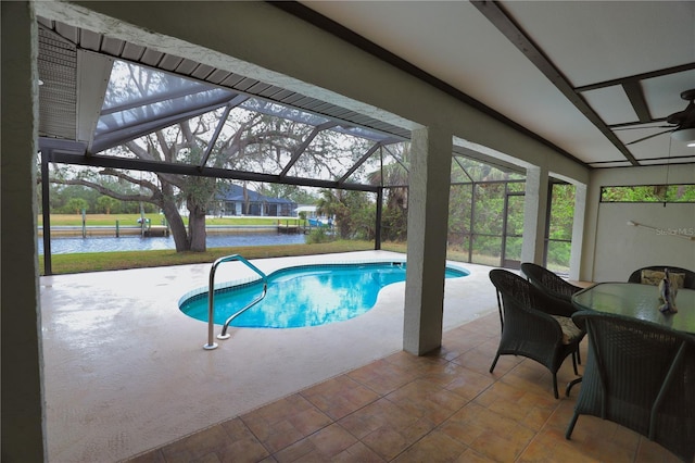 view of pool with a patio, a water view, and glass enclosure