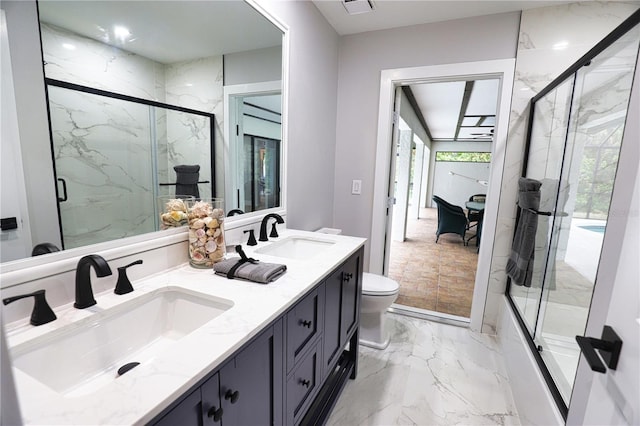 bathroom featuring vanity, toilet, and an enclosed shower