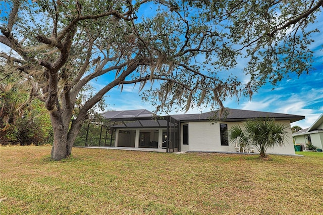 back of property featuring a yard and a lanai