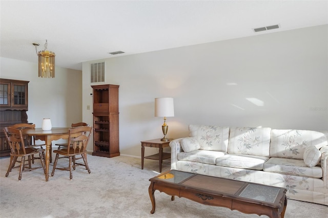 carpeted living room featuring a chandelier