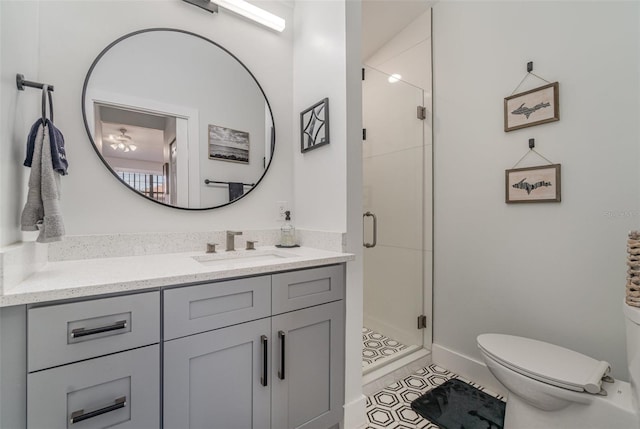 bathroom with tile patterned flooring, vanity, toilet, and an enclosed shower