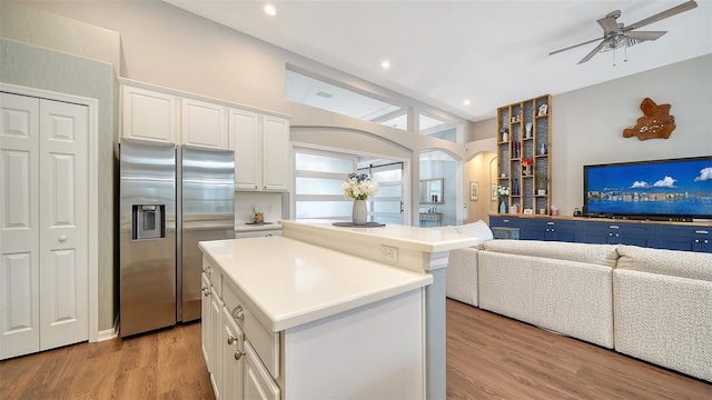 kitchen with white cabinets, a center island, stainless steel refrigerator with ice dispenser, and light hardwood / wood-style flooring