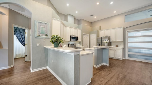 8334 Sailing Loop, Lakewood Ranch, FL 34202 - kitchen with stainless steel appliances, wood finished floors, a kitchen island, white cabinets, and light countertops