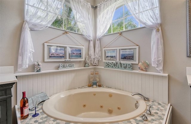 bathroom featuring vanity and a relaxing tiled tub