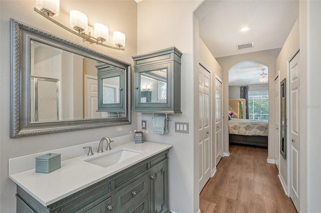 bathroom featuring ceiling fan, hardwood / wood-style floors, vanity, and an enclosed shower