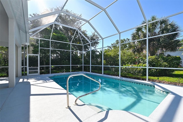 view of swimming pool featuring glass enclosure and a patio