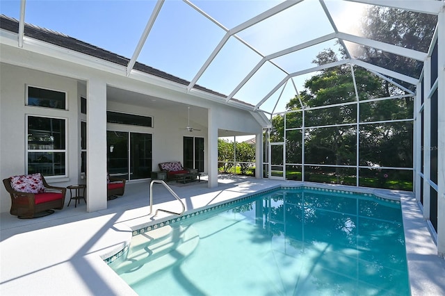 view of swimming pool featuring ceiling fan, a lanai, and a patio