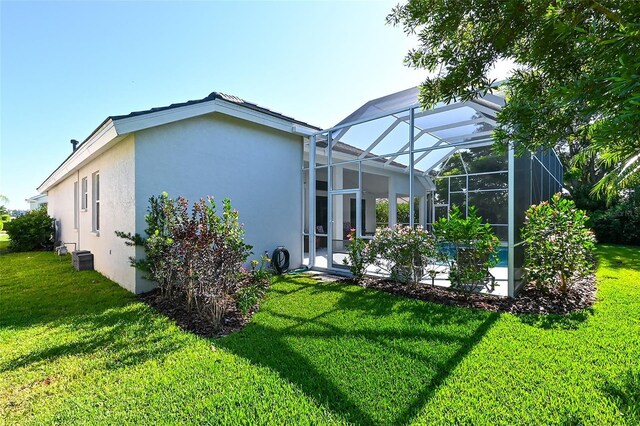 8334 Sailing Loop, Lakewood Ranch, FL 34202 - back of property with stucco siding, a yard, and a lanai
