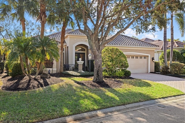 mediterranean / spanish house with a front lawn and a garage