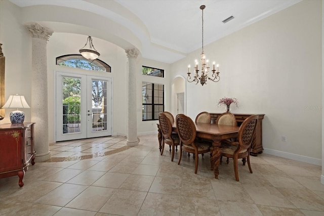 dining area featuring french doors, ornate columns, and a notable chandelier