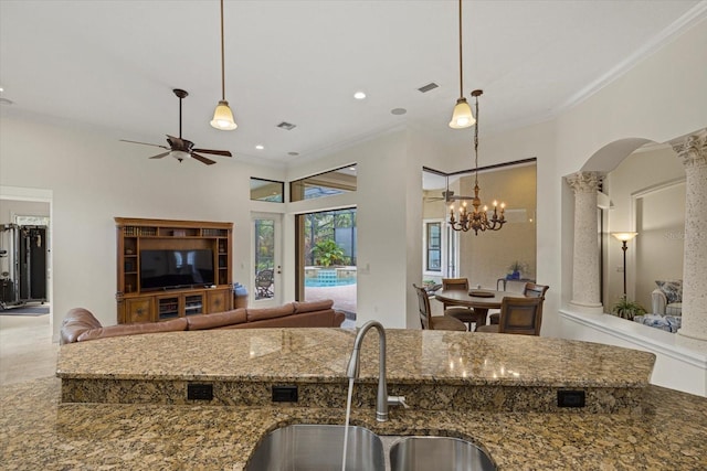 kitchen with pendant lighting, decorative columns, crown molding, and sink