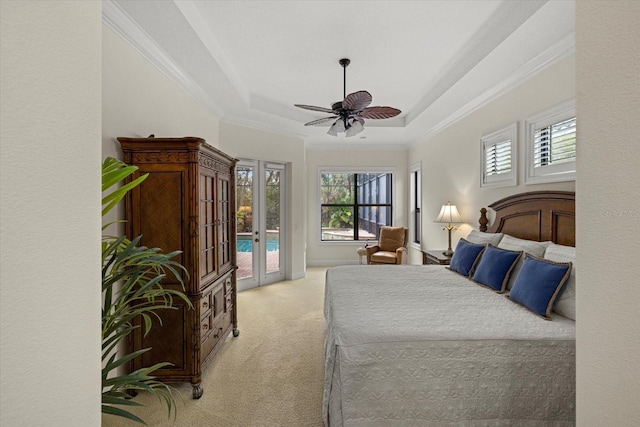 carpeted bedroom featuring multiple windows, access to outside, a raised ceiling, and ceiling fan