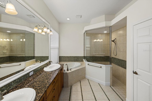 bathroom featuring plus walk in shower, vanity, and tile patterned flooring