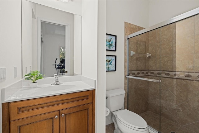 bathroom with vanity, toilet, and a shower with door