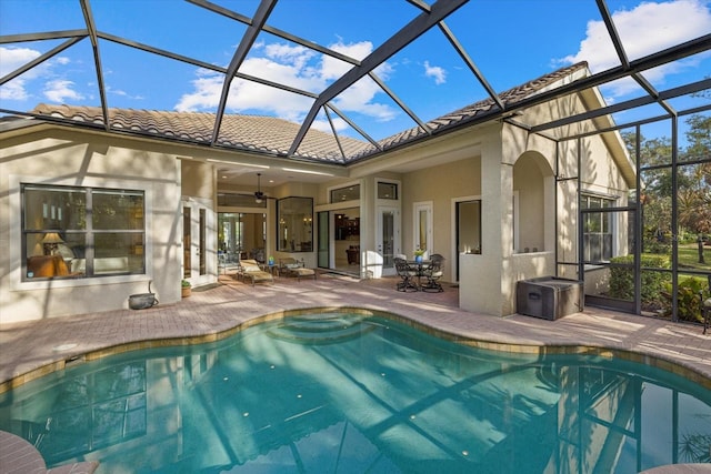 view of pool with a lanai, a patio area, and ceiling fan