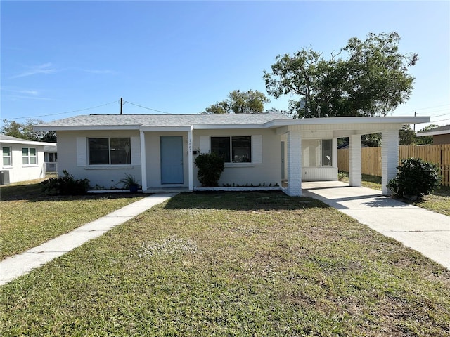 ranch-style home featuring a front lawn and a carport