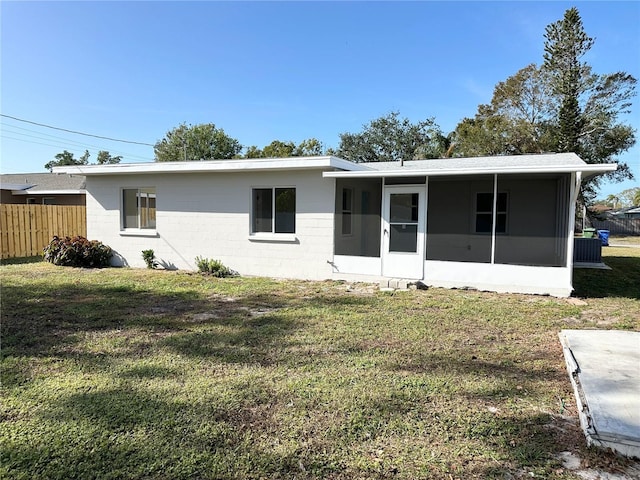 rear view of property with a sunroom and a lawn