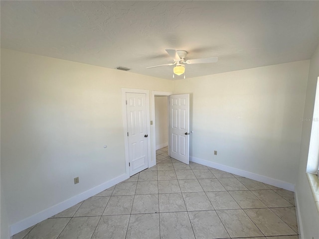 empty room featuring ceiling fan and light tile patterned flooring