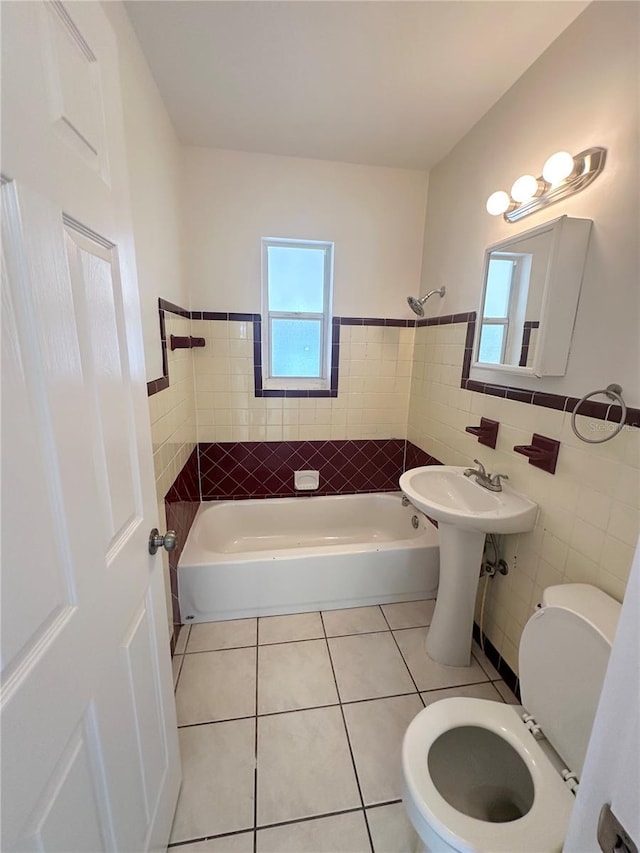 bathroom featuring tile patterned flooring, shower / bathtub combination, toilet, and tile walls