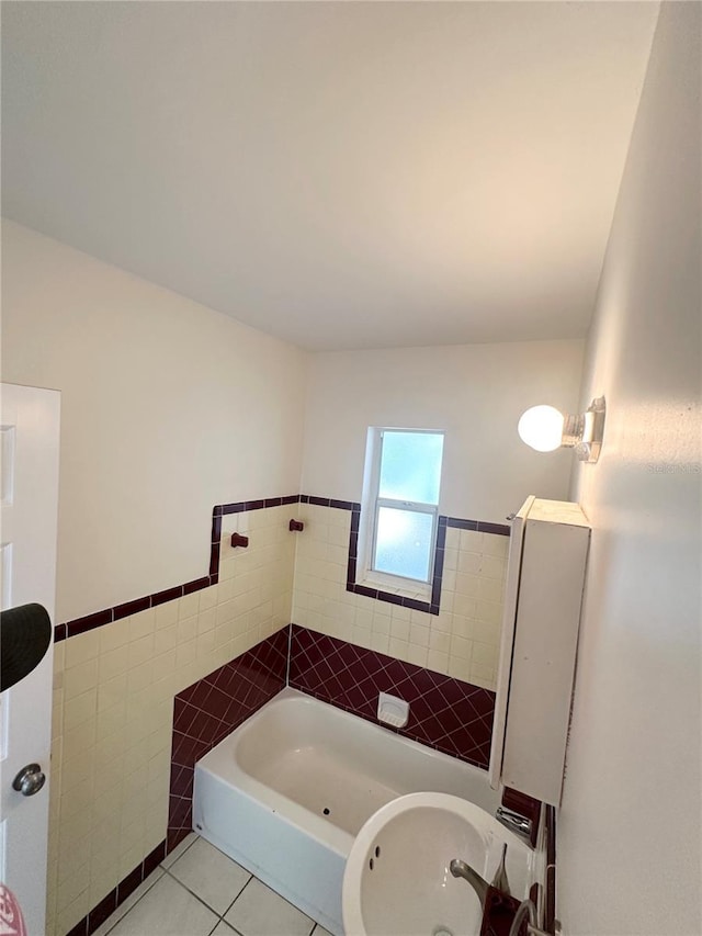 bathroom with a shower, tile patterned flooring, tile walls, and sink